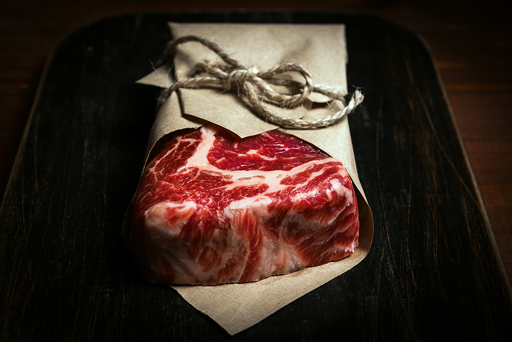 Freshly cut rib eye steak wrapped in butcher shop paper