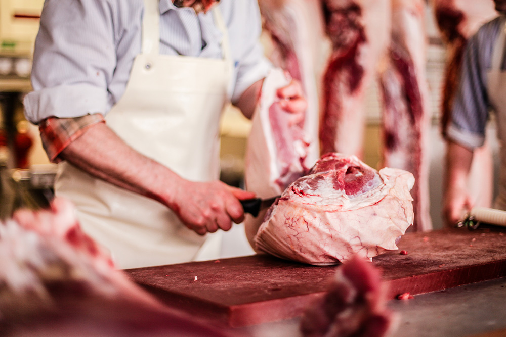 Butcher trimming pork